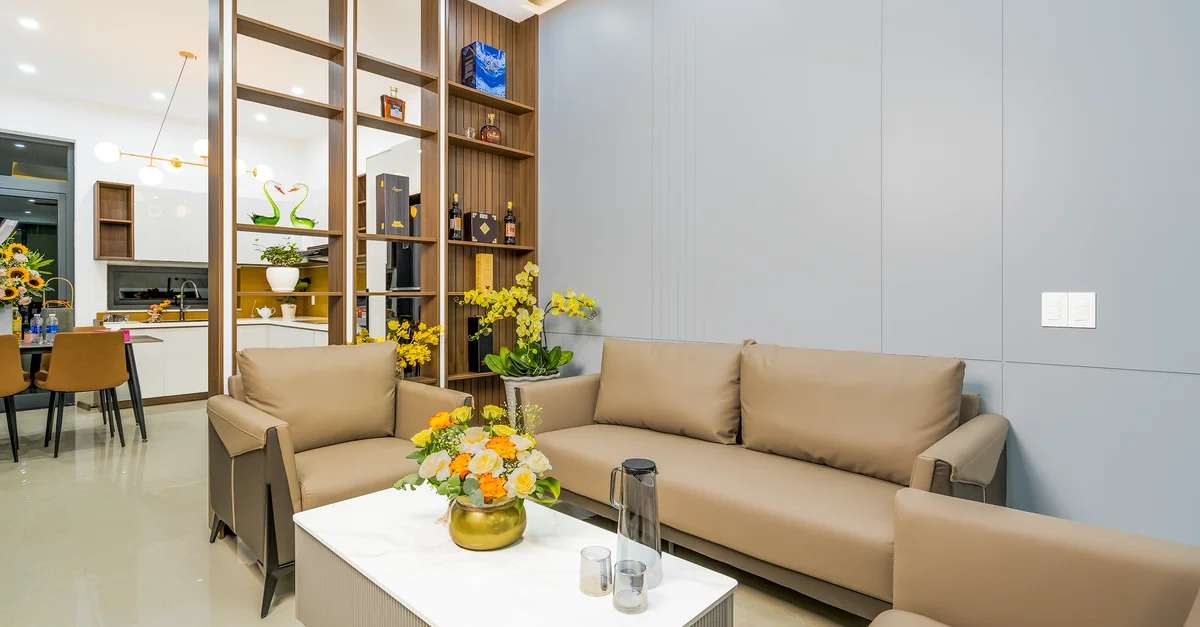 Salon élégant avec des meubles modernes et des fleurs vibrantes embellissant l'espace.