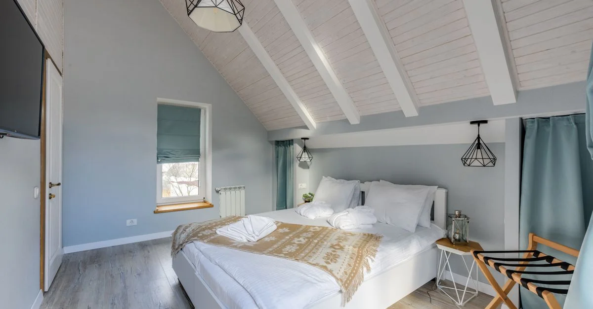 Chambre minimaliste lumineuse et accueillante avec des éléments de décoration rustiques et une lumière naturelle.